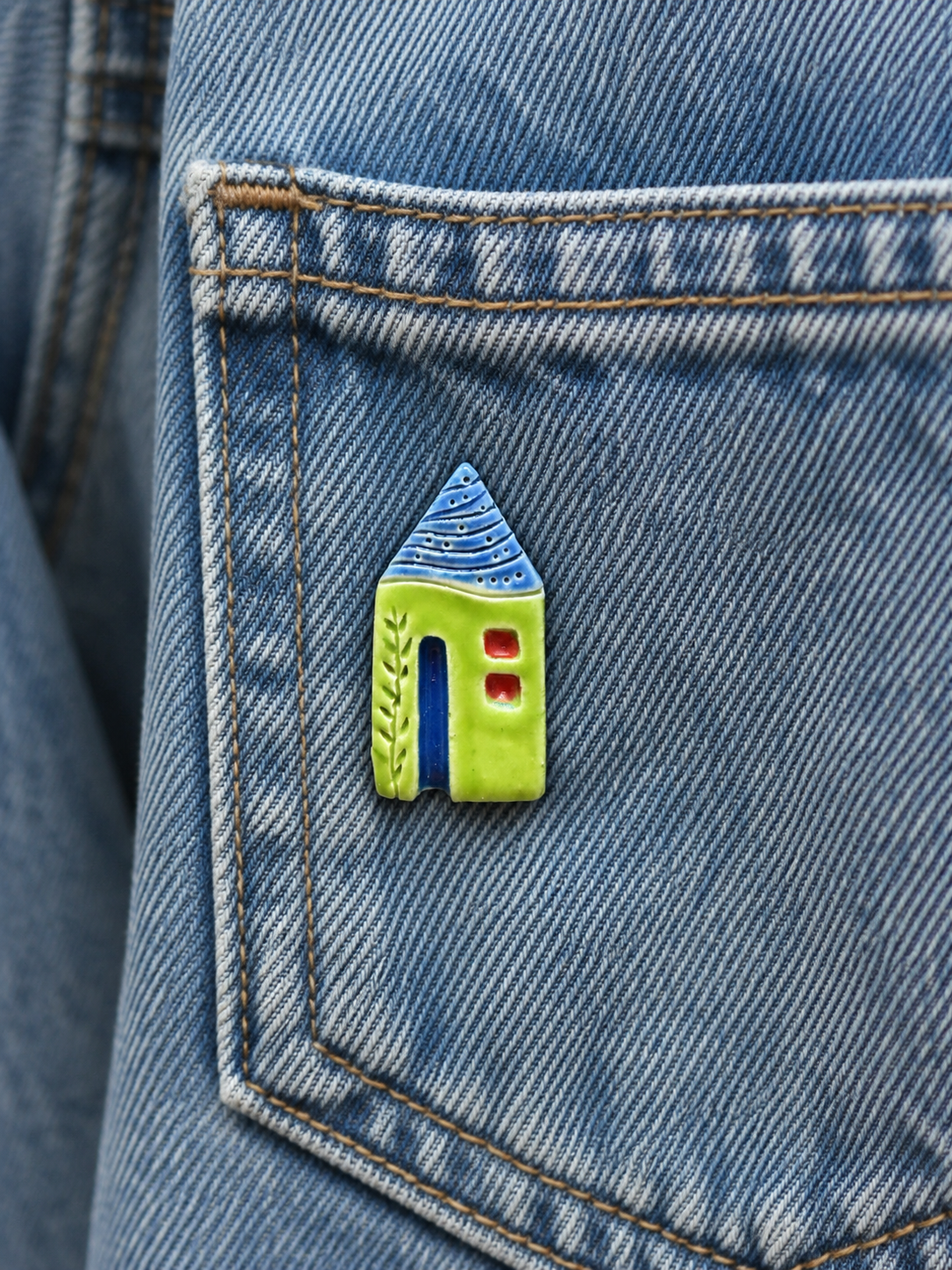 Ceramic house pin on denim